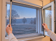 Fliegengitter im Winter: Spannrahmen wird von innen aus dem Kunststofffenster genommen